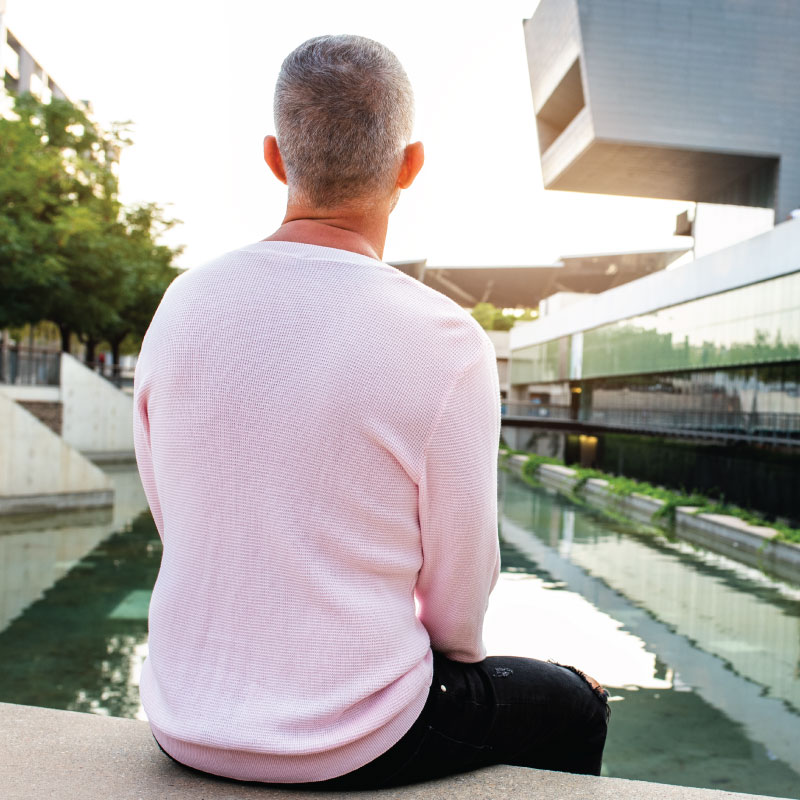 Male reflecting by fountain in city