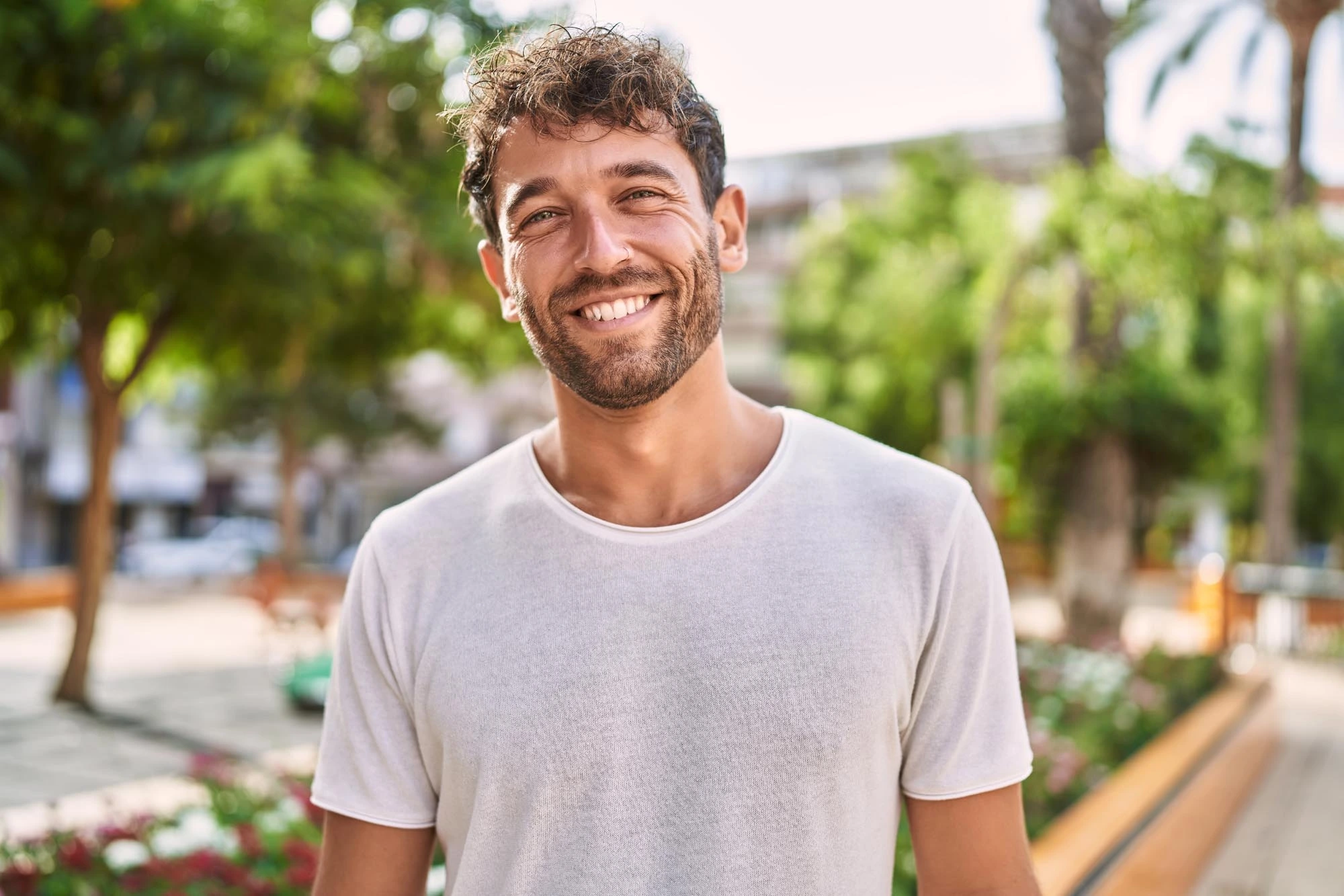 Smiling man in a sunny park.